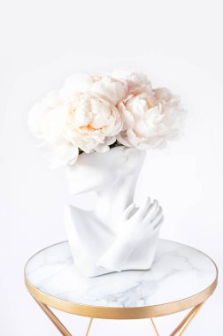 İnsan kafası vazosundaki beyaz şakayıklar.