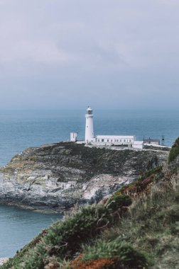 South Stack Deniz Feneri, Galler, Anglesey, İngiltere. Kutsal Ada 'nın kuzey-batı kıyısında küçük bir adanın zirvesine inşa edilmiştir. Gemileri aşağıdaki tehlikeli kayalara karşı uyarmak için 1809 'da inşa edildi..