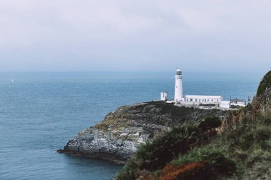 South Stack Deniz Feneri, Galler, Anglesey, İngiltere. Kutsal Ada 'nın kuzey-batı kıyısında küçük bir adanın zirvesine inşa edilmiştir. Gemileri aşağıdaki tehlikeli kayalara karşı uyarmak için 1809 'da inşa edildi..