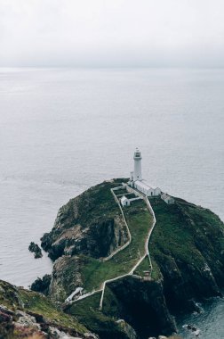South Stack Deniz Feneri, Galler, Anglesey, İngiltere. Kutsal Ada 'nın kuzey-batı kıyısında küçük bir adanın zirvesine inşa edilmiştir. Gemileri aşağıdaki tehlikeli kayalara karşı uyarmak için 1809 'da inşa edildi..