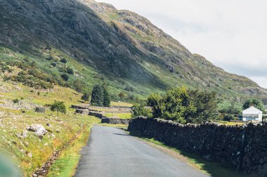 Wast Water veya Wastwater yakınlarında kırsal viraj yolu. Göl Wasdale 'de, Lake District Ulusal Parkı' nın batı kesiminde bir vadi, İngiltere, güzel bir yaz günü ve mavi bulutlu bir gökyüzü bulunmaktadır.