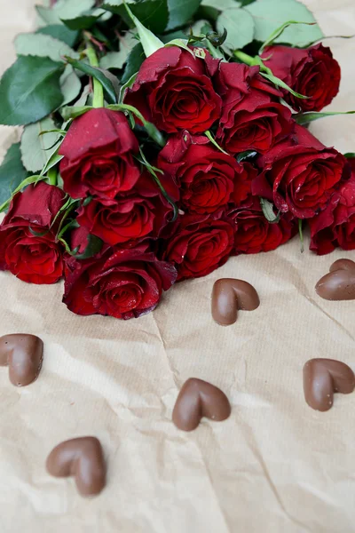 Rosas vermelhas escuras e corações de chocolate — Fotografia de Stock