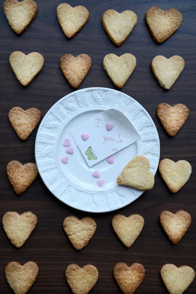 Placa Blanca con Nota Te Amo y Galletas en Forma de Corazón alrededor —  Fotos de Stock