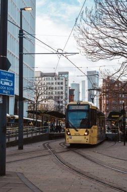 MANCHESTER, ENGLAND, İngiltere - 28 Kasım 2025 Manchester şehir merkezi, Metrolink tramvay durağı St Peters Meydanı 'nda farklı noktalara giden tramvaylar
