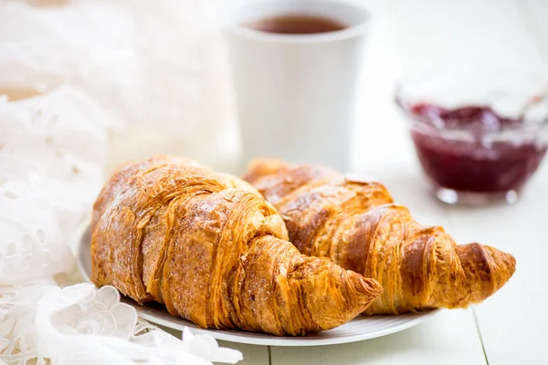 Friss croissant-t, a porcukrot, a csésze teát, és a Strawberry Jam — Stock Fotó