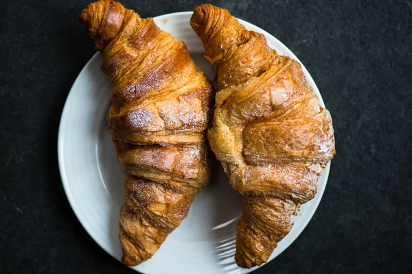 Dvě čerstvé croissanty s polevou jsou připraveny k snídani — Stock fotografie