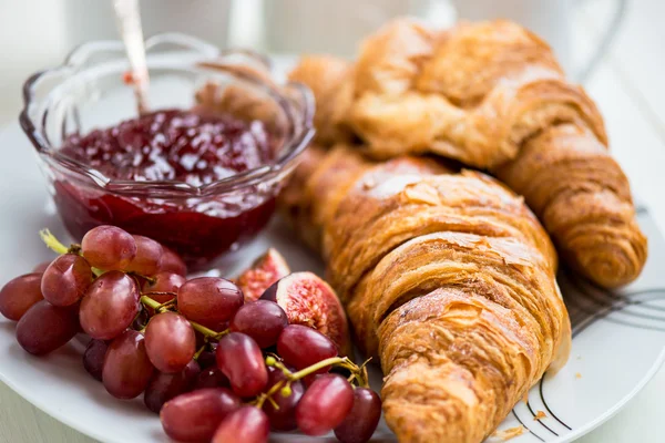 Croissant-t, a porcukrot, a csésze teát, a szőlő, a cukor és a Strawberry — Stock Fotó