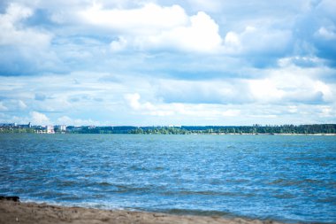 Mavi deniz, bulutlu gökyüzü, Sandy Beach ve Backgrou şehir