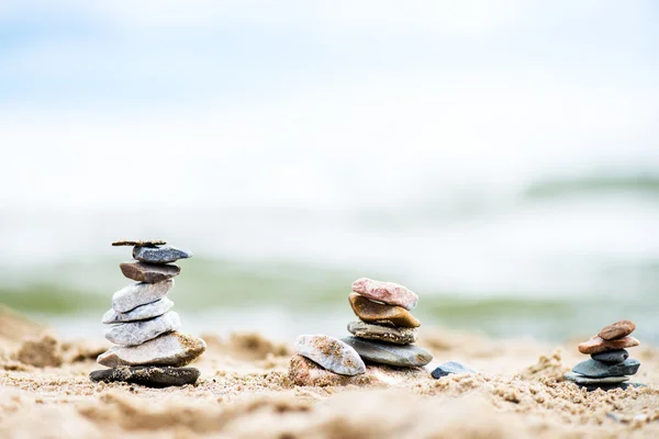 Kövek piramisok a homok. A tenger a háttérben — Stock Fotó