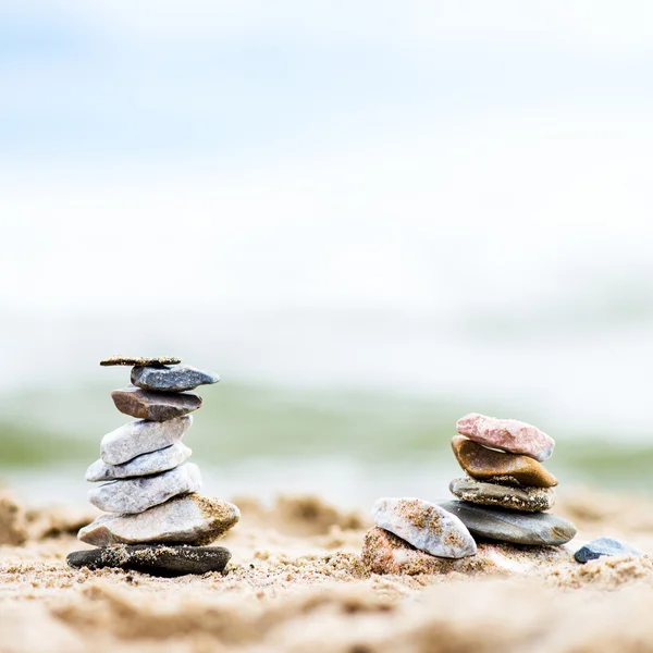 Kövek piramisok a homok. A tenger a háttérben — Stock Fotó
