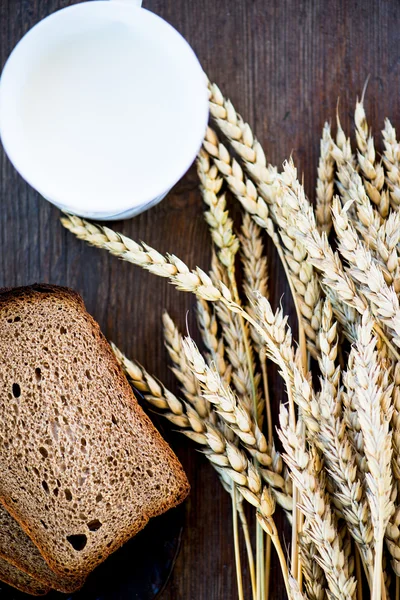 Buğday, ekmek ve süt ahşap arka plan üzerinde — Stok fotoğraf