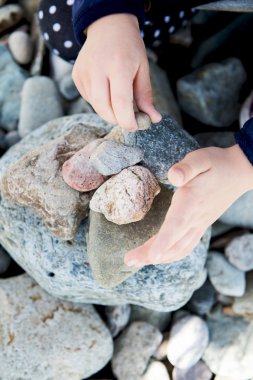 Landudno, İngiltere, İngiltere'de deniz taşlarla oynayan kız