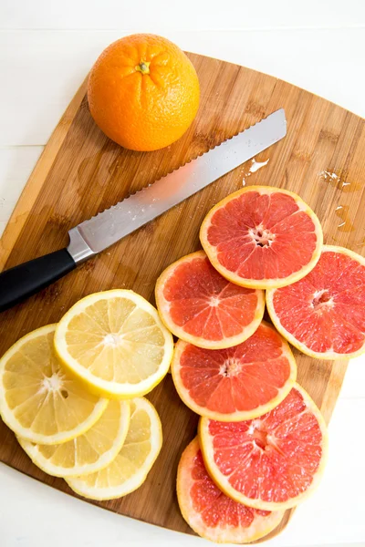 Rebanadas de cítricos. Naranja, pomelo y cuchillo — Foto de Stock