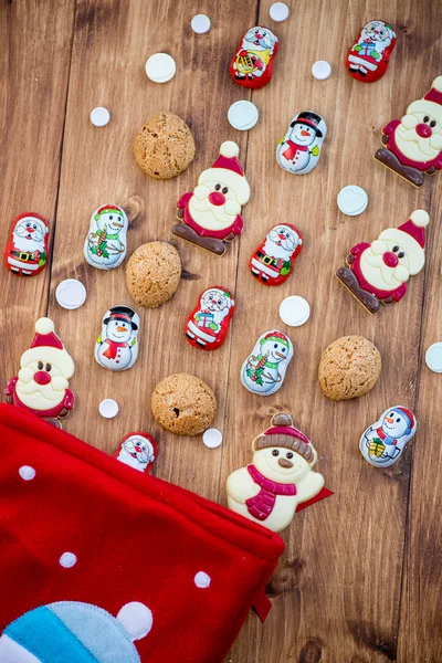 Chocolate Santas, Snowman and Biscuits near Christmas Stocking — Stock Photo, Image