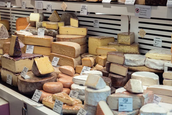 市場の冷蔵庫で異なるチーズの展示会で撮影した写真 — ストック写真