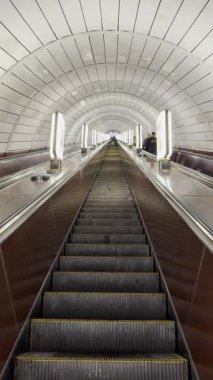 Kyiv metrosuna atmosferik iniş: loş ışıklar, fayanslı duvarlar ve yürüyen merdivenlerin ritmik uğultusu. Şehrin altında sakin bir şehir anı.