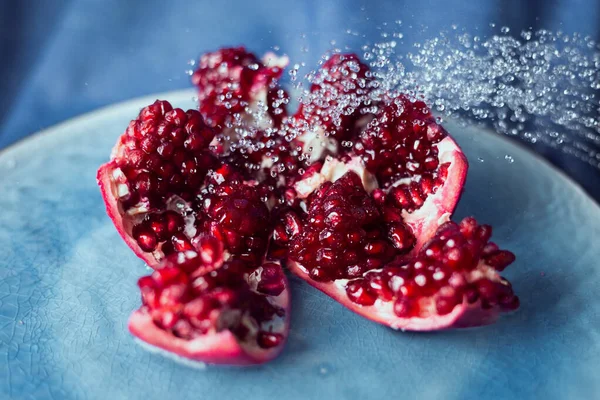 Lezzetli, mavi bir tabakta kesilmiş nar meyvesi..
