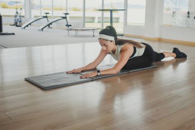 Spor salonunda egzersiz yapan genç bir fitness kadını.