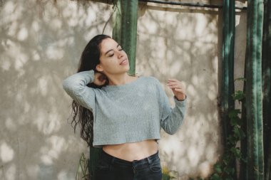 Parktaki kaktüs bitkilerinin arka planında mutlu güzel bir kadın.