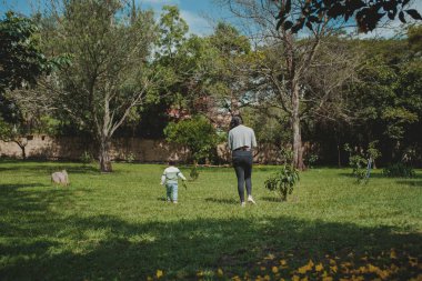Genç anne oğluyla parkta yürüyor.