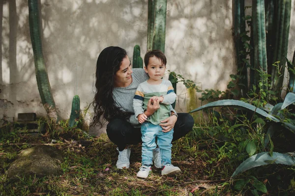 Junge Mutter Mit Ihrem Sohn Vor Dem Hintergrund Von Kakteenpflanzen — Stockfoto
