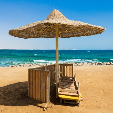 Gerdanlı güneş şemsiyesi ile ıssız beach.