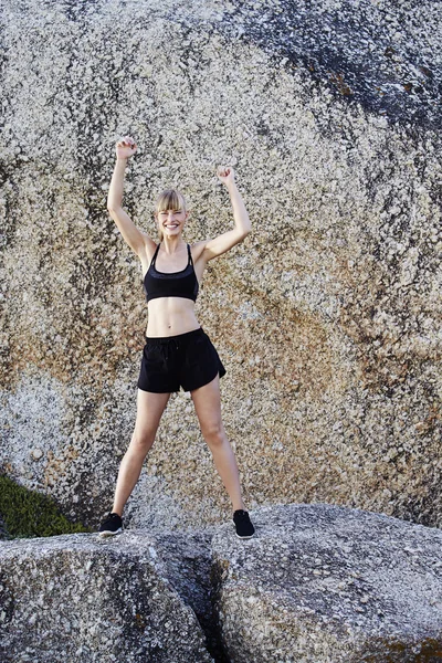 Kayaların üzerinde duran güzel atlet — Stok fotoğraf
