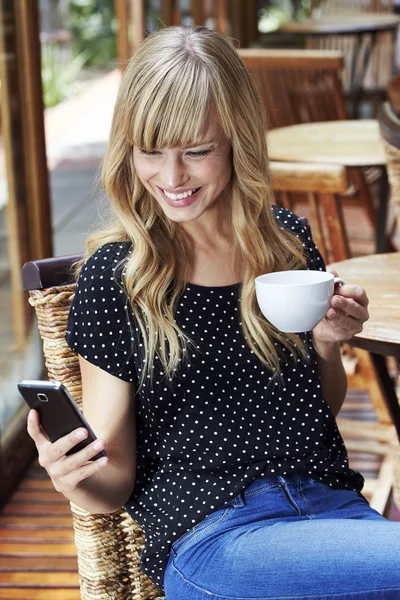 Hermosa mujer mensajes de texto en la cafetería — Foto de Stock