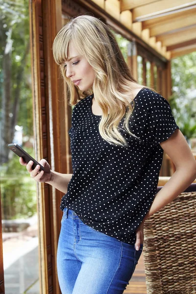 Blonde jonge vrouw texting — Stockfoto