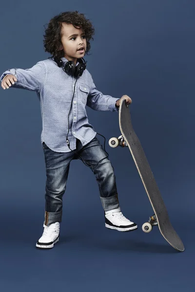 Skateboarder boy in blue studio — Stock Photo, Image