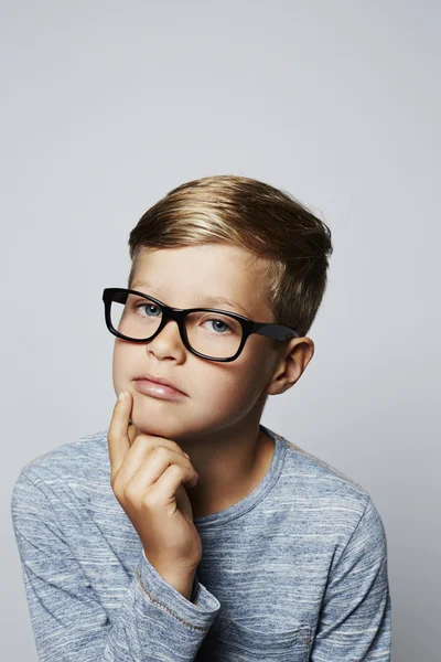 Задумчивый мальчик в очках — стоковое фото