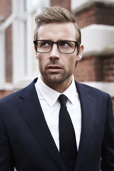 Handsome businessman in black suit Stock Photo by ©sanneberg 102341378