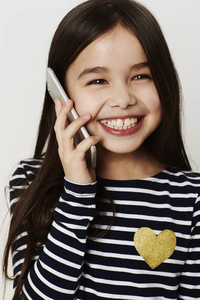 Девушка улыбается с мобильного телефона — стоковое фото