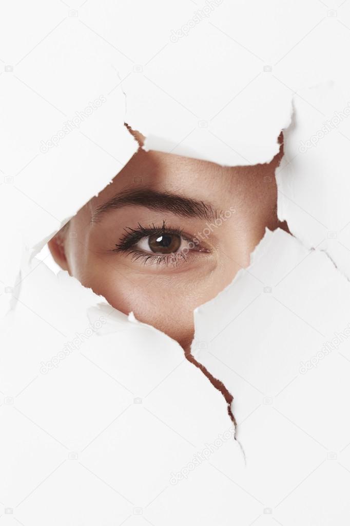 woman looking through tears in paper
