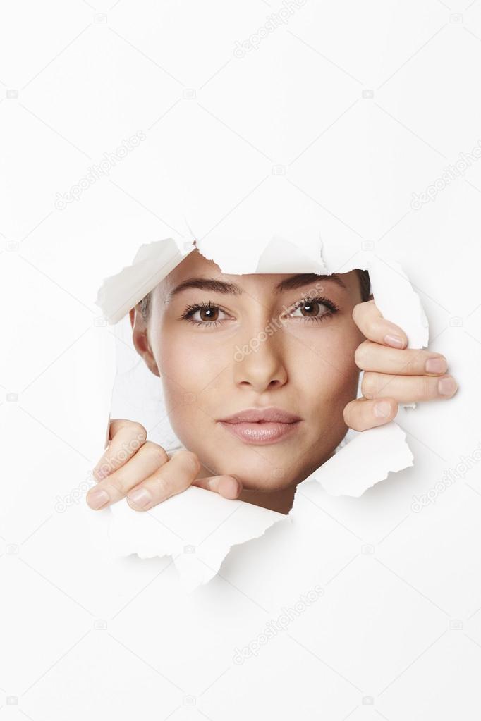 woman through tear in paper