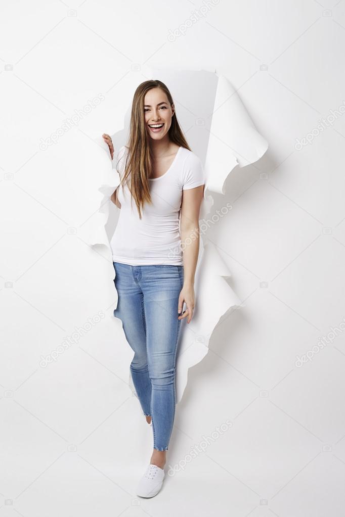 woman emerging from ripped paper