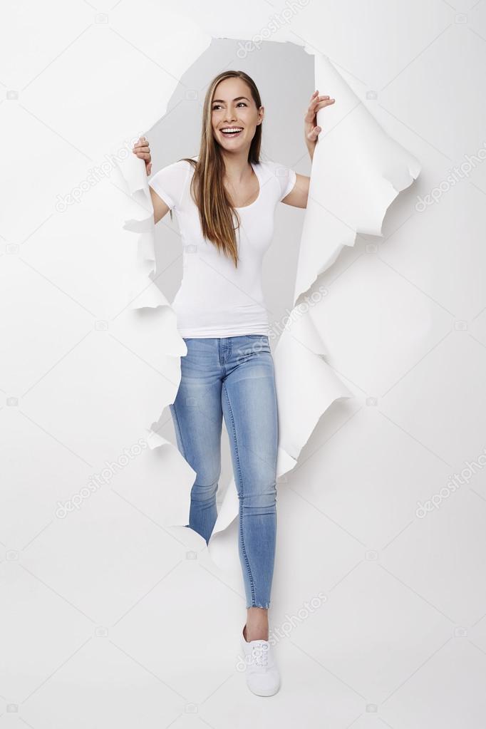 woman emerging from torn paper