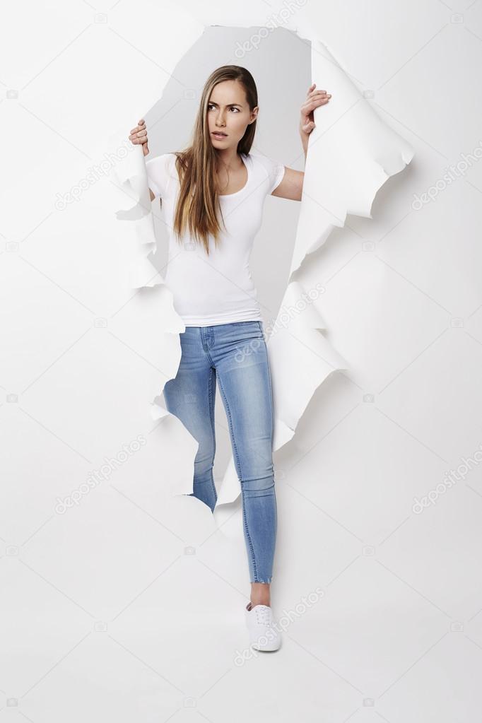 woman emerging from torn paper