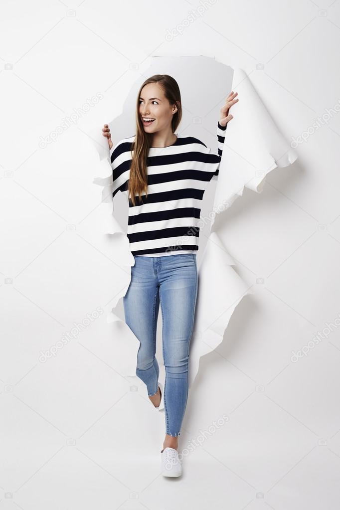 woman emerging from torn paper