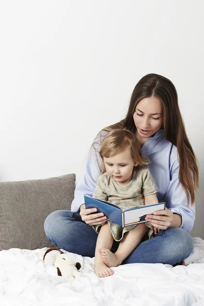 Jovem mãe lendo a filha — Fotografia de Stock