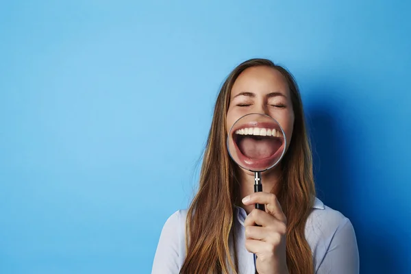 Mulher rindo através de lupa — Fotografia de Stock