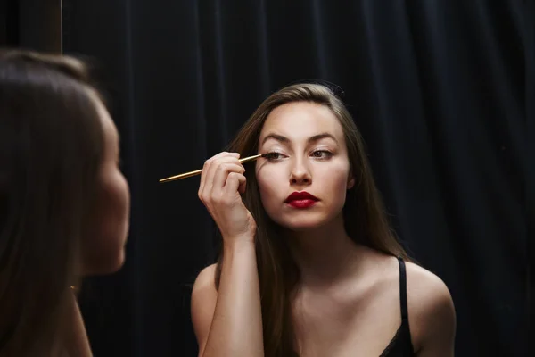 Красивая женщина наносит макияж — стоковое фото