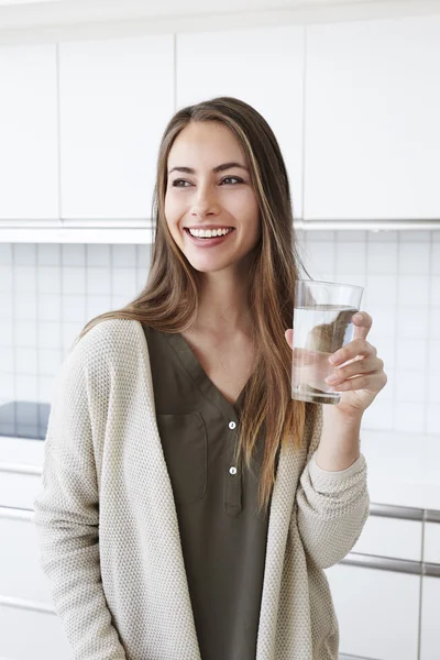 Woman in kitchen with water — Stock Photo, Image
