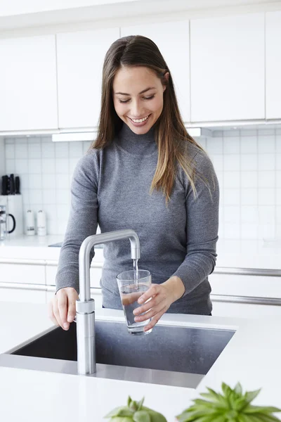 Güzel kadın cam su ile doldurma