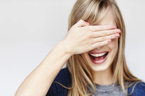 Young blond woman with hand over eyes — Stock Photo, Image