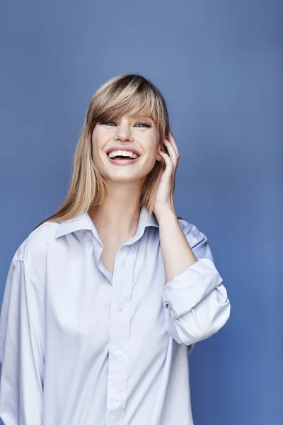 Glückliche blonde Schönheit im blauen Hemd — Stockfoto