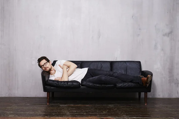 Молодий чоловік розслабляється на дивані — стокове фото