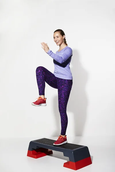 Beautiful athlete stepping on gym step — Stock Photo, Image