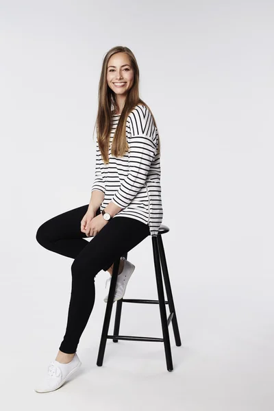 Beautiful woman sitting on stool — Stock Photo, Image