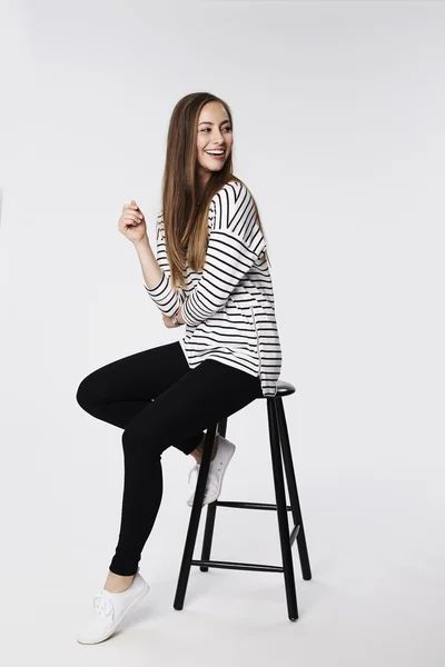 Beautiful woman sitting on stool — Stock Photo, Image